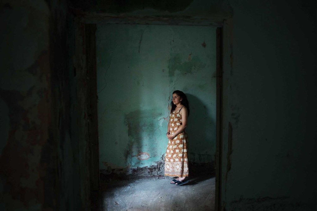 Maria ritratta in una delle stanze liberate da cumuli di rifiuti, pochi giorni dopo l'insediamento nella Tenuta Vaselli.